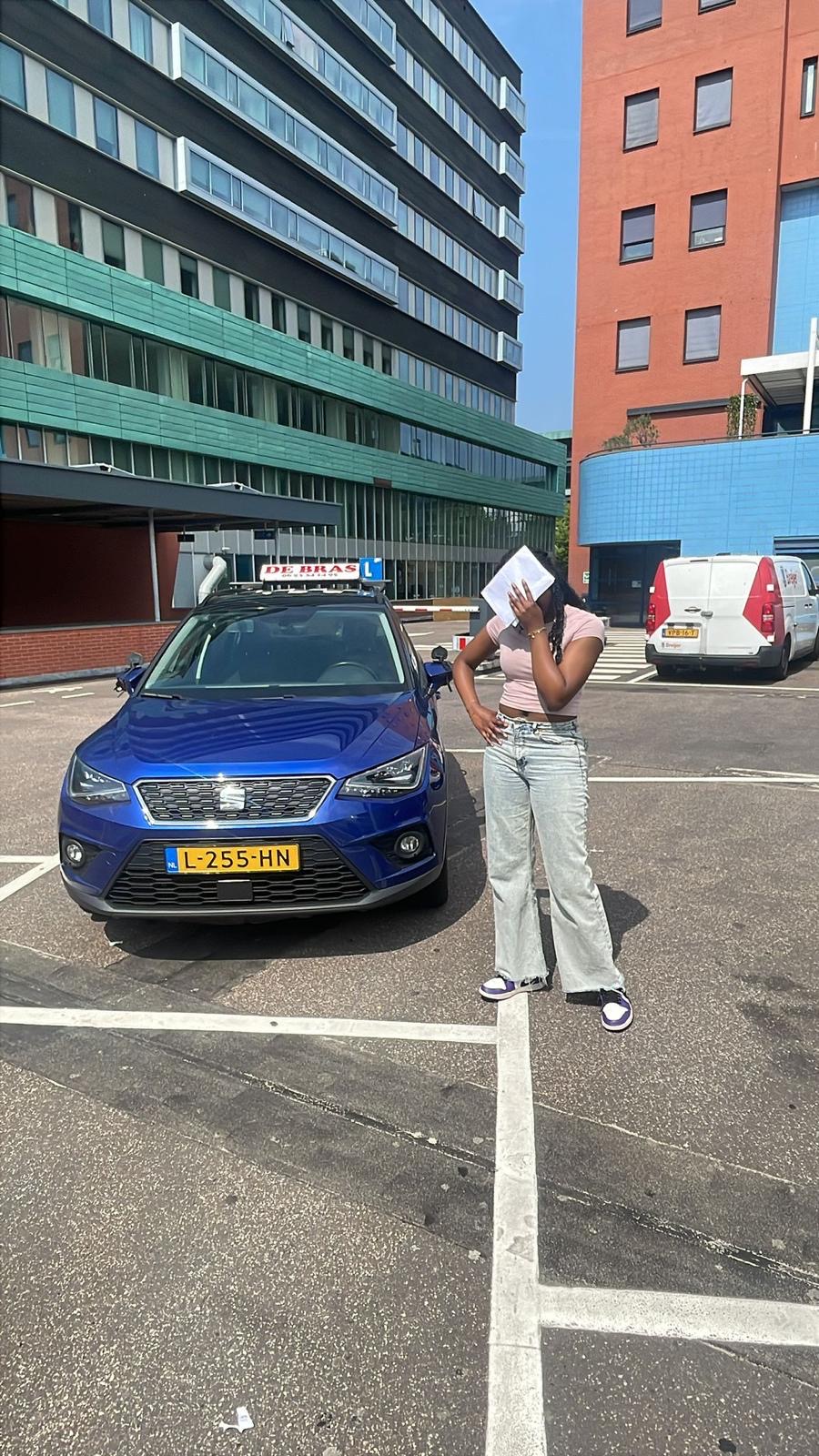 Geslaagde leerling van Rijschool De Bras bij de lesauto
