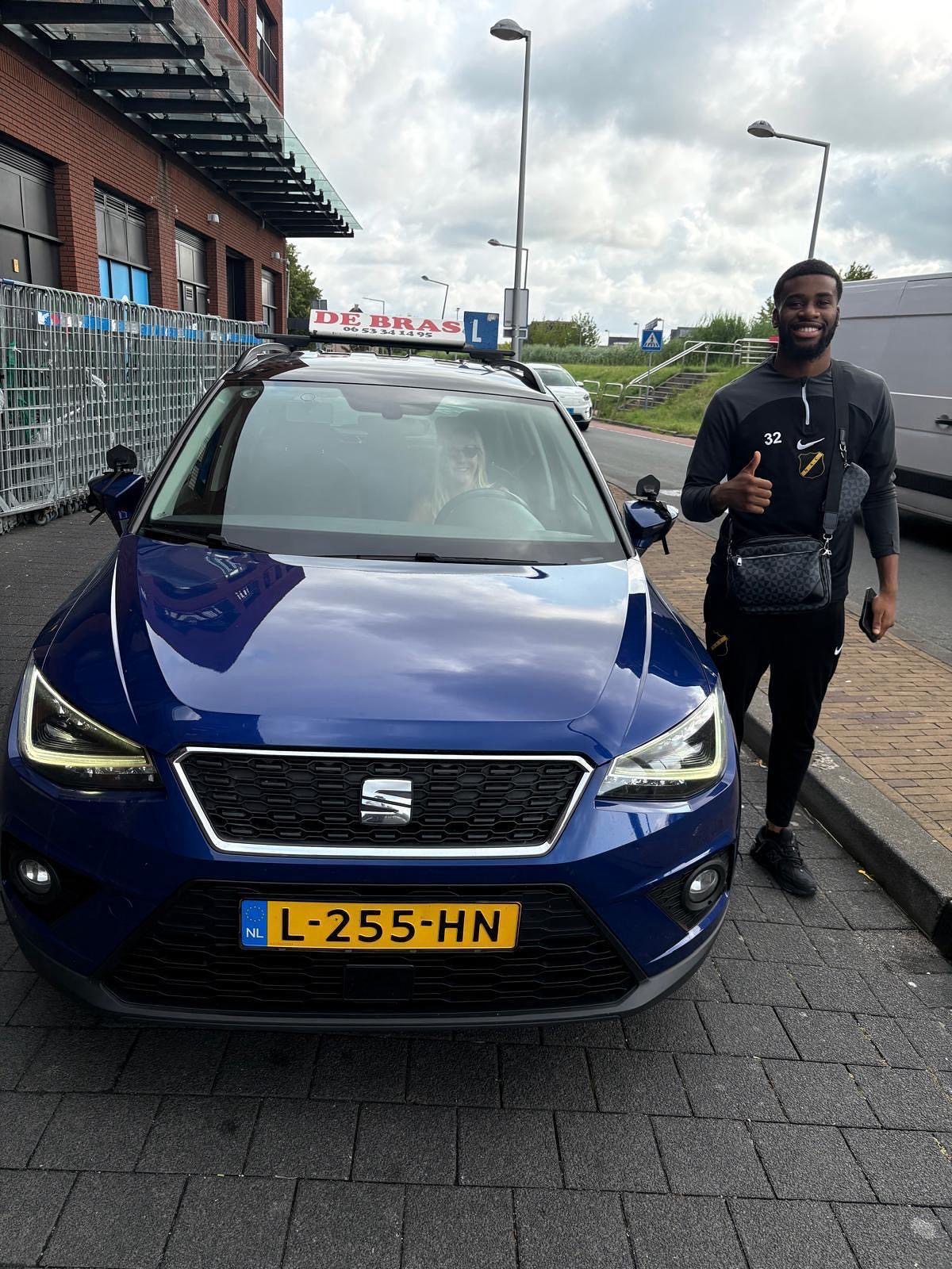 Geslaagde leerling van Rijschool De Bras bij de lesauto